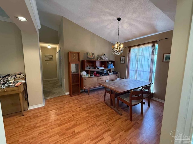 1640 Steven Dr, Gulf Breeze, FL 32563 - dining room featuring lofted ceiling, a chandelier, light wood-style floors, and a textured ceiling