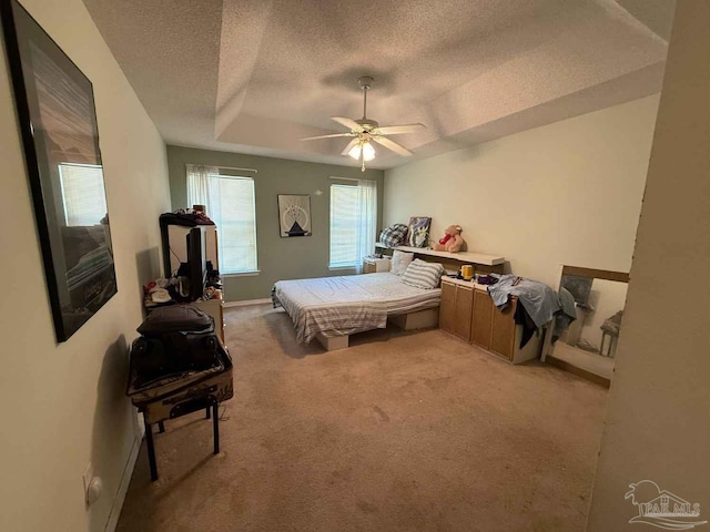 1640 Steven Dr, Gulf Breeze, FL 32563 - bedroom with a textured ceiling, a tray ceiling, light carpet, and a ceiling fan