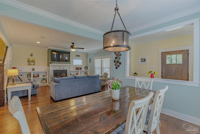 dining room featuring baseboards, crown molding, hardwood / wood-style flooring, and a healthy amount of sunlight