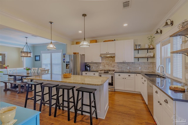 kitchen with open shelves, stainless steel appliances, under cabinet range hood, a sink, and visible vents