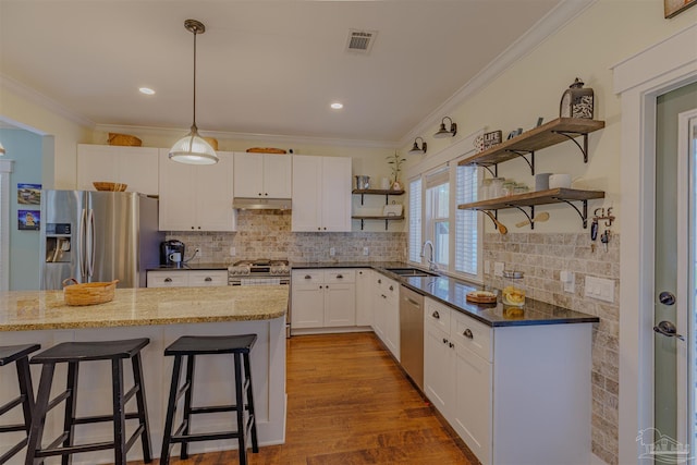 kitchen featuring visible vents, appliances with stainless steel finishes, under cabinet range hood, a sink, and open shelves