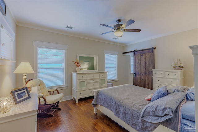 bedroom featuring multiple windows, dark wood-style flooring, a barn door, and visible vents