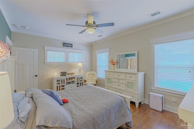 bedroom featuring wood finished floors, ornamental molding, and visible vents