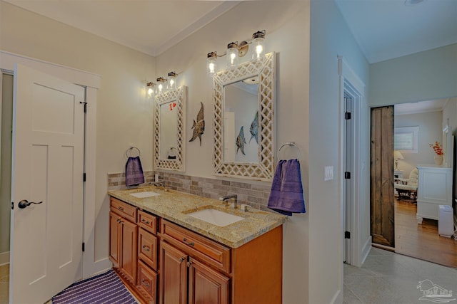 bathroom featuring tile patterned floors, a sink, tasteful backsplash, and double vanity