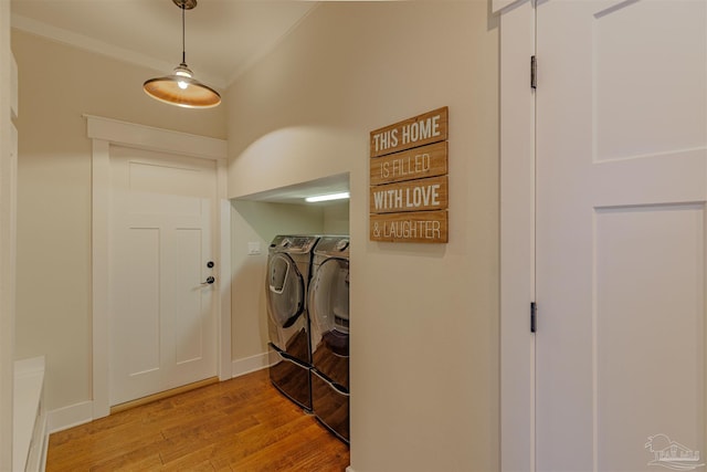 washroom featuring crown molding, light wood finished floors, baseboards, laundry area, and separate washer and dryer