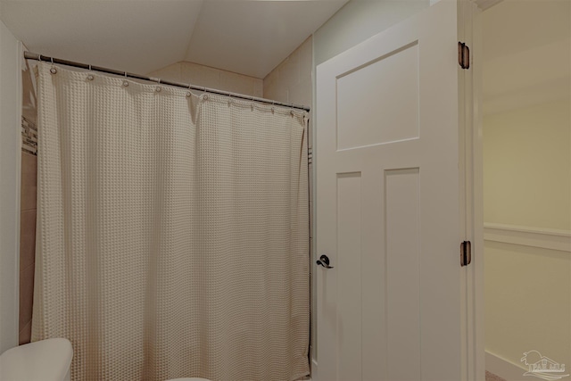 full bath featuring lofted ceiling, toilet, and curtained shower
