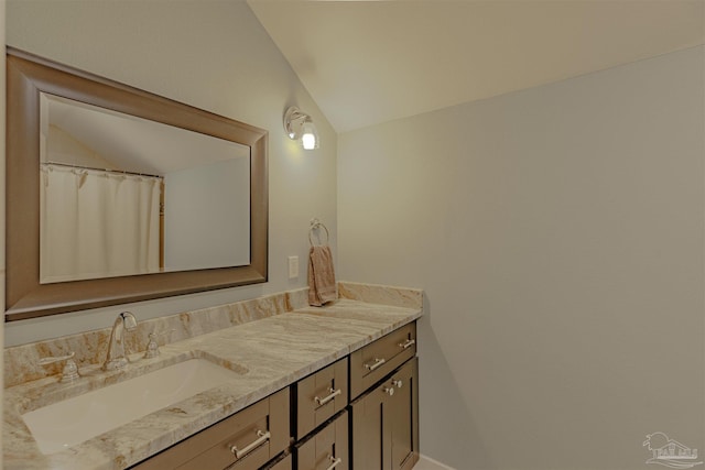bathroom featuring lofted ceiling and vanity