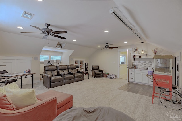 living area with visible vents, lofted ceiling, and a ceiling fan