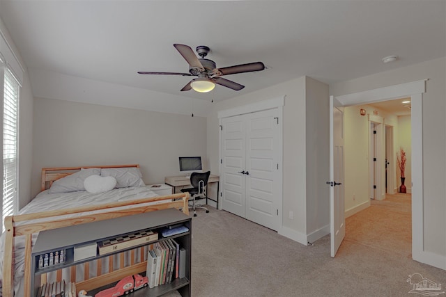 bedroom featuring light carpet, baseboards, a closet, and a ceiling fan