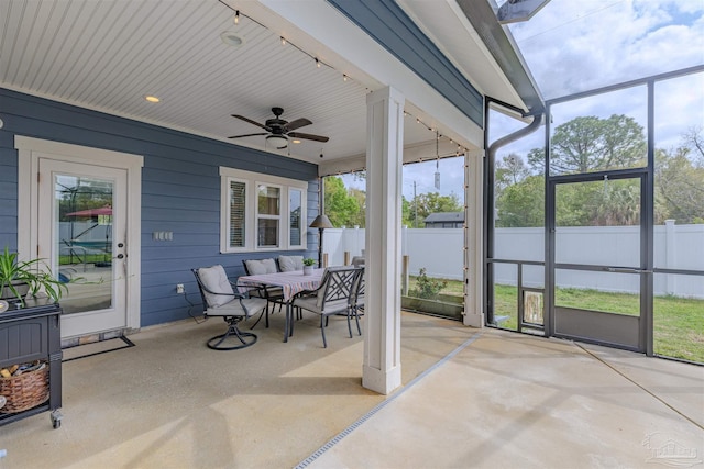 sunroom / solarium with rail lighting, outdoor dining space, and a ceiling fan