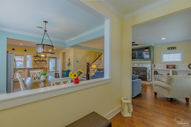 interior space with plenty of natural light, wood finished floors, and ornamental molding