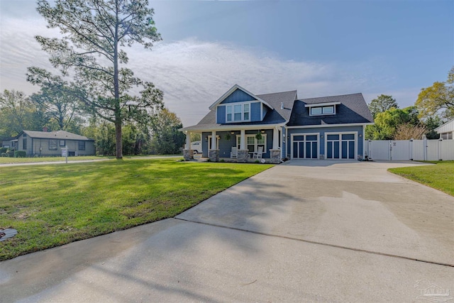 craftsman inspired home featuring fence, driveway, a front yard, a gate, and a porch