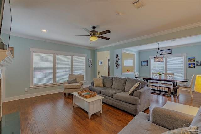 living room featuring dark wood-style floors, baseboards, visible vents, ceiling fan, and ornamental molding
