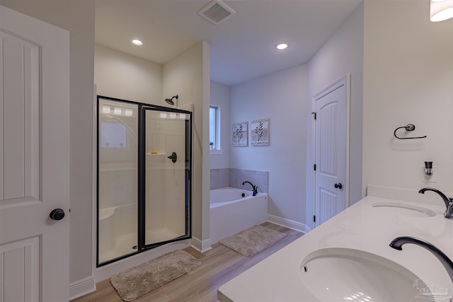 bathroom with wood-type flooring, vanity, and separate shower and tub