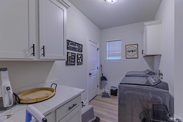 washroom featuring cabinets, light wood-type flooring, and independent washer and dryer