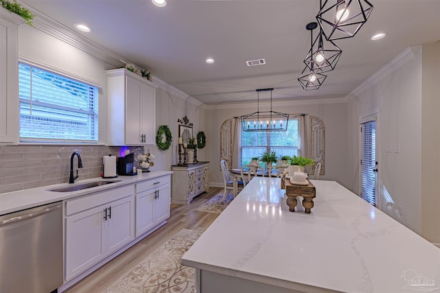 kitchen with white cabinetry, dishwasher, sink, hanging light fixtures, and light hardwood / wood-style floors