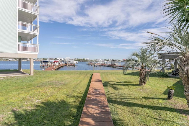 view of dock featuring a water view and a yard