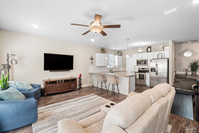 living room featuring ceiling fan, dark hardwood / wood-style flooring, and sink