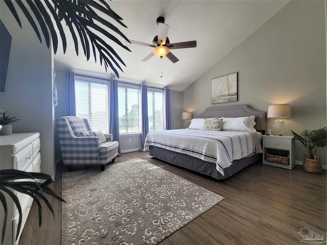 bedroom with ceiling fan, vaulted ceiling, a textured ceiling, wood finished floors, and baseboards