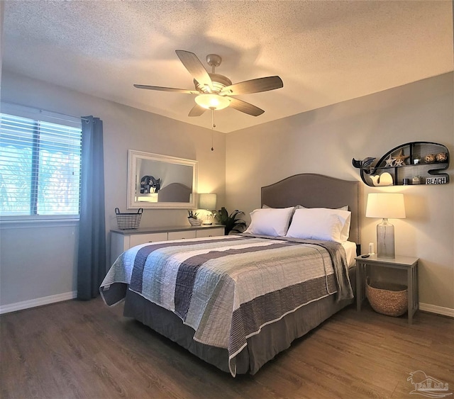 bedroom with a textured ceiling, wood finished floors, and baseboards