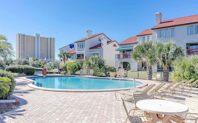 community pool with fence and a patio