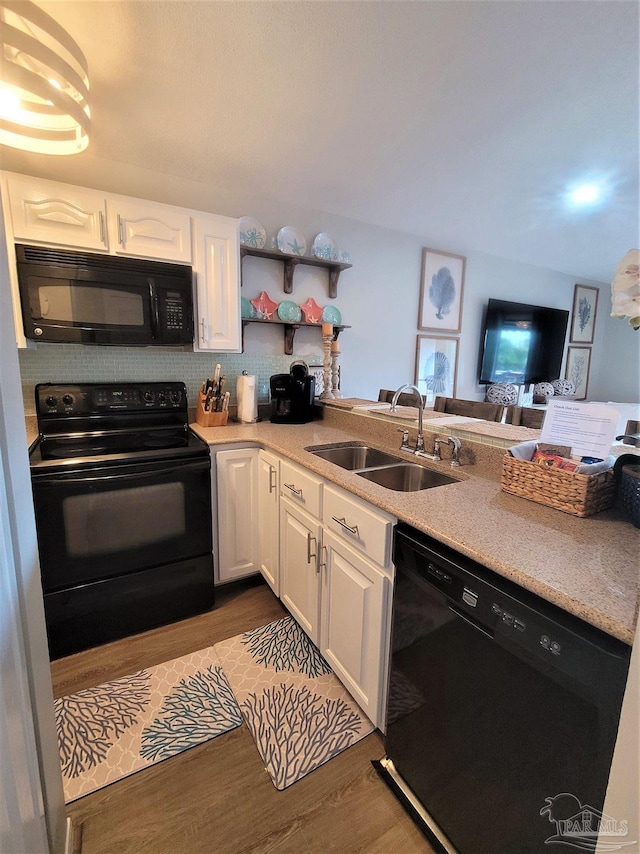 kitchen featuring dark wood-style floors, white cabinetry, a sink, and black appliances