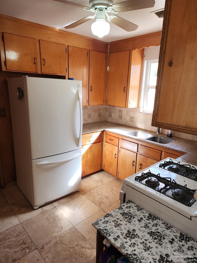 kitchen with white appliances, backsplash, ceiling fan, and sink