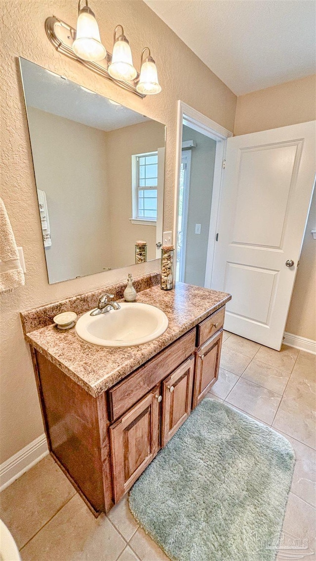 6214 Plum Orchard Way, Crestview, FL 32536 - bathroom with a textured wall, tile patterned floors, vanity, and baseboards