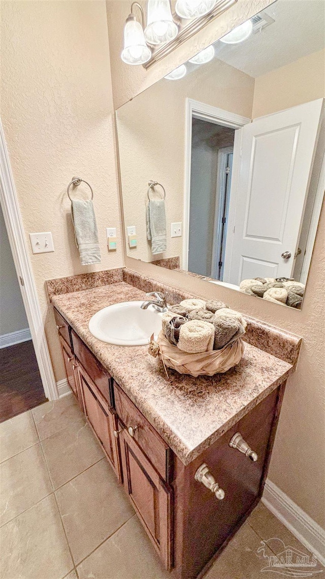 6214 Plum Orchard Way, Crestview, FL 32536 - bathroom with tile patterned flooring, vanity, a textured wall, and baseboards