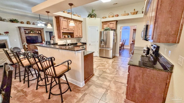 6214 Plum Orchard Way, Crestview, FL 32536 - kitchen with appliances with stainless steel finishes, a peninsula, a breakfast bar, hanging light fixtures, and a ceiling fan