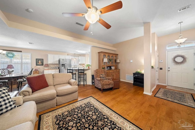 living room featuring wood-type flooring and ceiling fan