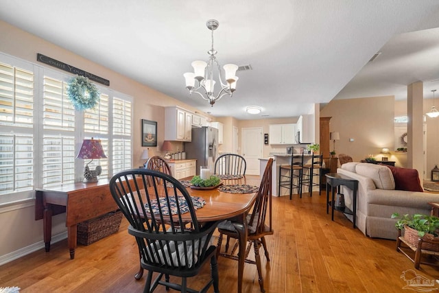 dining space featuring a chandelier and light hardwood / wood-style floors