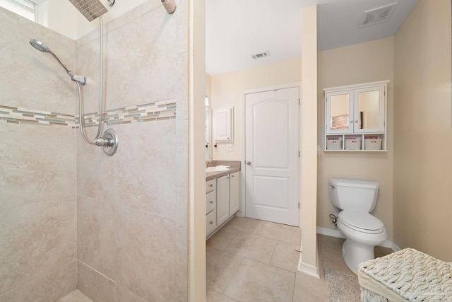 bathroom featuring tile patterned floors, vanity, toilet, and tiled shower