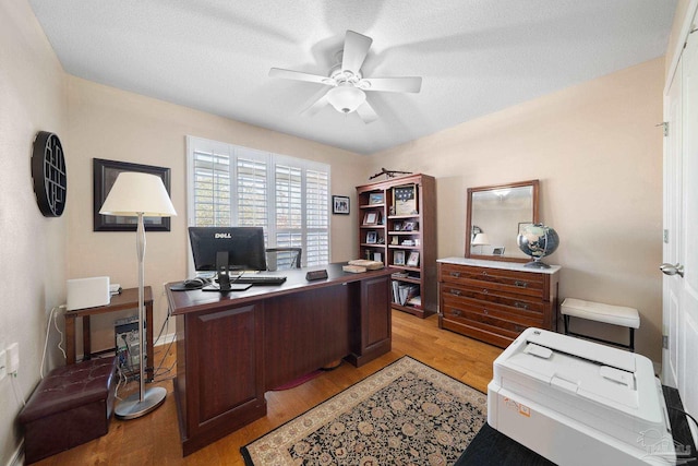 home office with ceiling fan, a textured ceiling, and light hardwood / wood-style flooring