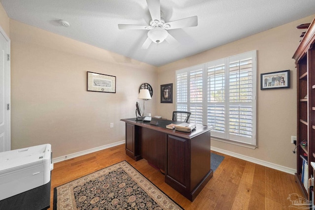 office space with a textured ceiling, light wood-type flooring, and ceiling fan