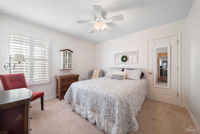 bedroom with ceiling fan, light colored carpet, and a textured ceiling