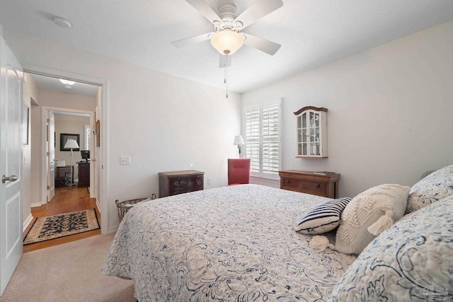 bedroom featuring a textured ceiling, light hardwood / wood-style flooring, and ceiling fan