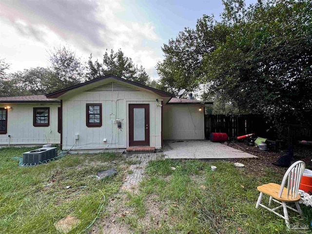 rear view of house with a yard, a patio, and central AC unit