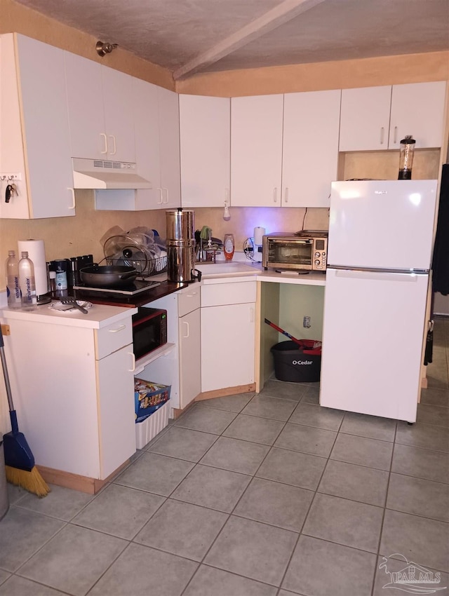 224 E Garden St Unit 306, Pensacola, FL 32502 - kitchen with freestanding refrigerator, under cabinet range hood, white cabinetry, and light countertops