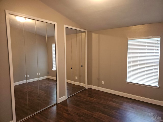 2201 Scenic Hwy Unit E-7, Pensacola, FL 32503 - unfurnished bedroom with two closets, dark wood finished floors, lofted ceiling, and baseboards