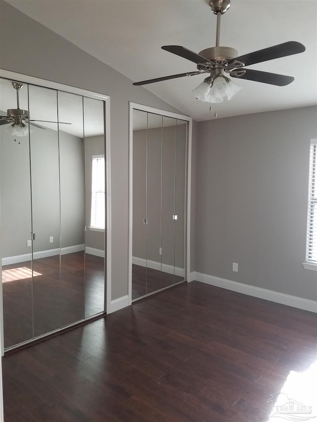 2201 Scenic Hwy Unit E-7, Pensacola, FL 32503 - unfurnished bedroom with two closets, wood finished floors, lofted ceiling, baseboards, and a ceiling fan