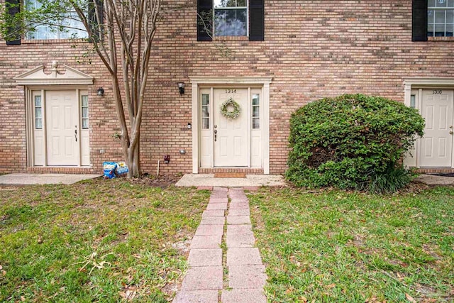 1314 Foxborough Dr, Pensacola, FL 32514 - view of exterior entry featuring a lawn and brick siding