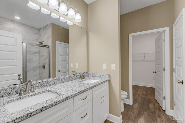 bathroom featuring hardwood / wood-style flooring, vanity, toilet, and an enclosed shower