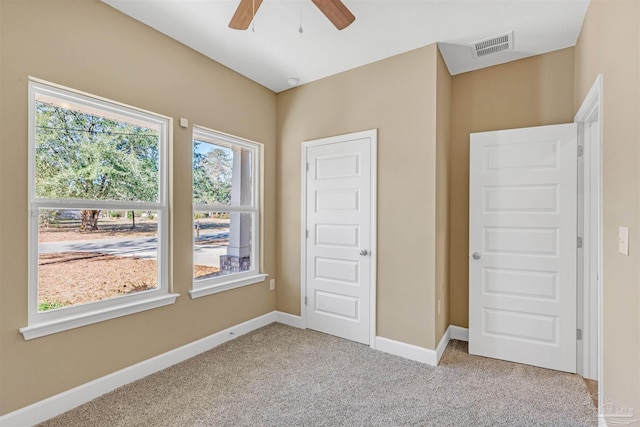 unfurnished bedroom with ceiling fan and light colored carpet