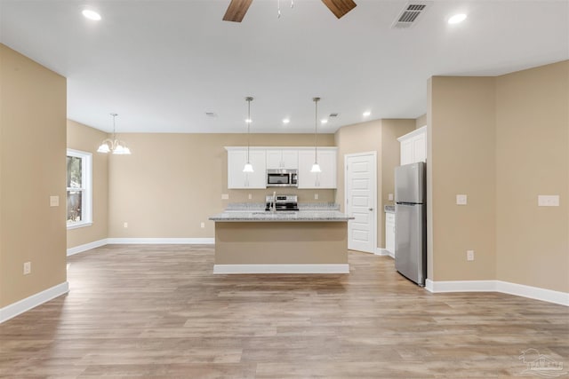 kitchen with white cabinetry, hanging light fixtures, a kitchen island with sink, stainless steel appliances, and light hardwood / wood-style floors