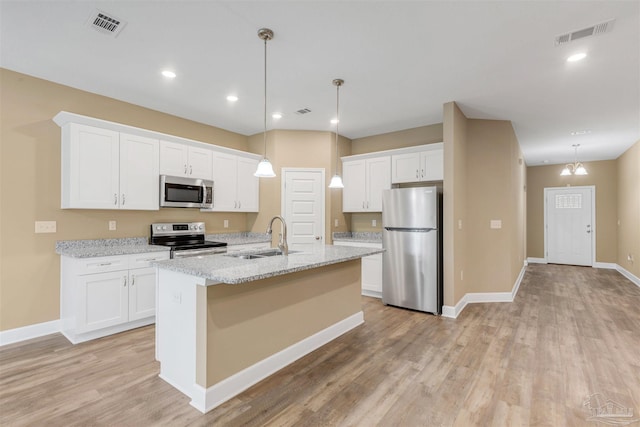 kitchen with white cabinetry, sink, hanging light fixtures, light stone counters, and stainless steel appliances