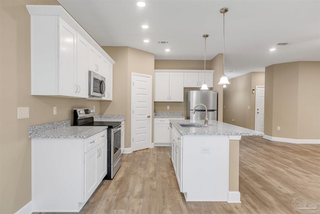 kitchen with sink, a center island with sink, appliances with stainless steel finishes, pendant lighting, and white cabinets