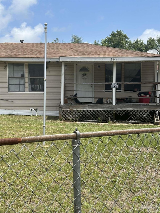 view of front facade with fence, a front lawn, and roof with shingles