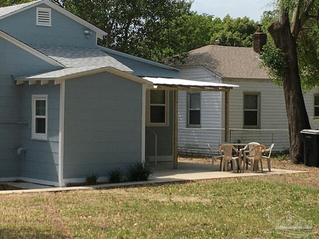 back of property with a patio area and a lawn