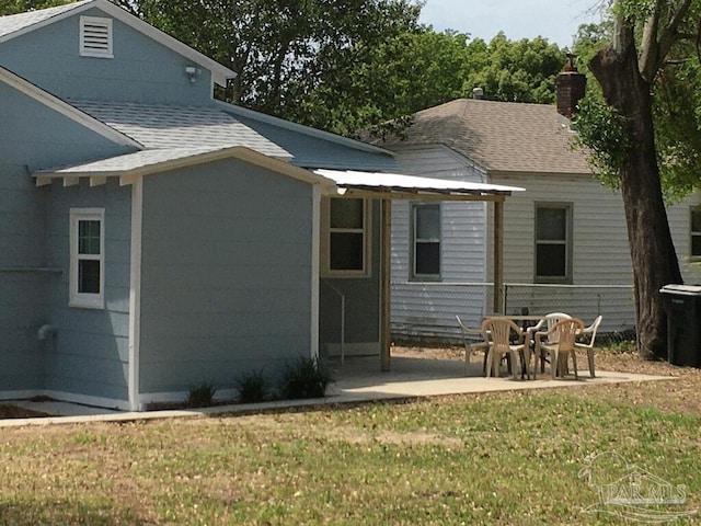 back of house featuring a patio area and a lawn